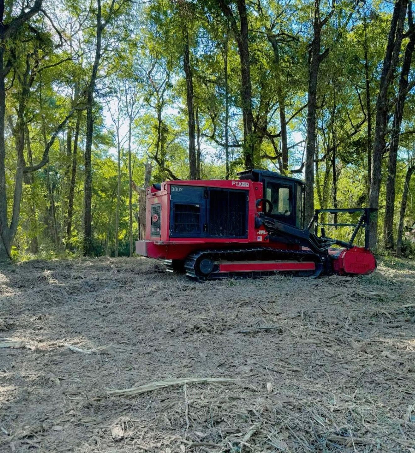 Forestry mulcher clearing brush in wooded acreage